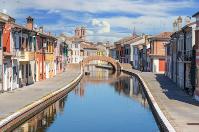 Historic buildings lining a canal in Comacchio, Italy.