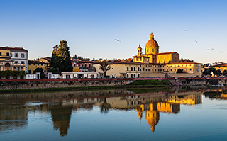 Historic buildings lining a river in Firenze, Italy.