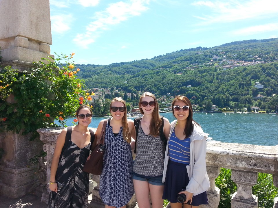 Four women posing in front of the beautiful Lake Maggiore in Italy.