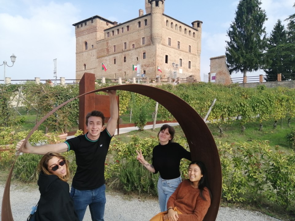 Four people posing with the Piedmont medieval castle in Italy.
