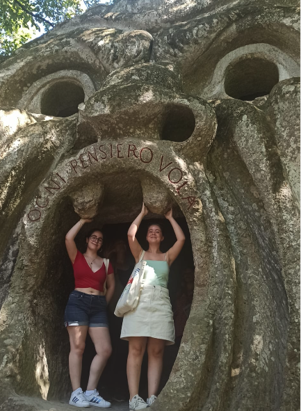 Two people standing in the mouth of a monster statue at Bomarzo Monsters Park in Italy.