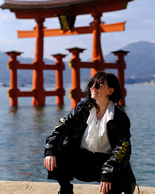 A student posing in front of Itsukushima in Miyajima Island, Japan.