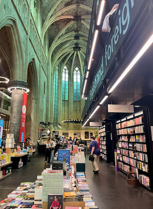 People walking in a historic church turned bookstore in Maastricht, Netherlands.