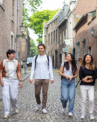 Four students walking along cobblestone streets in Maastricht, Netherlands.