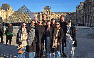 Students posing in front of Louvre museum in Paris, France.