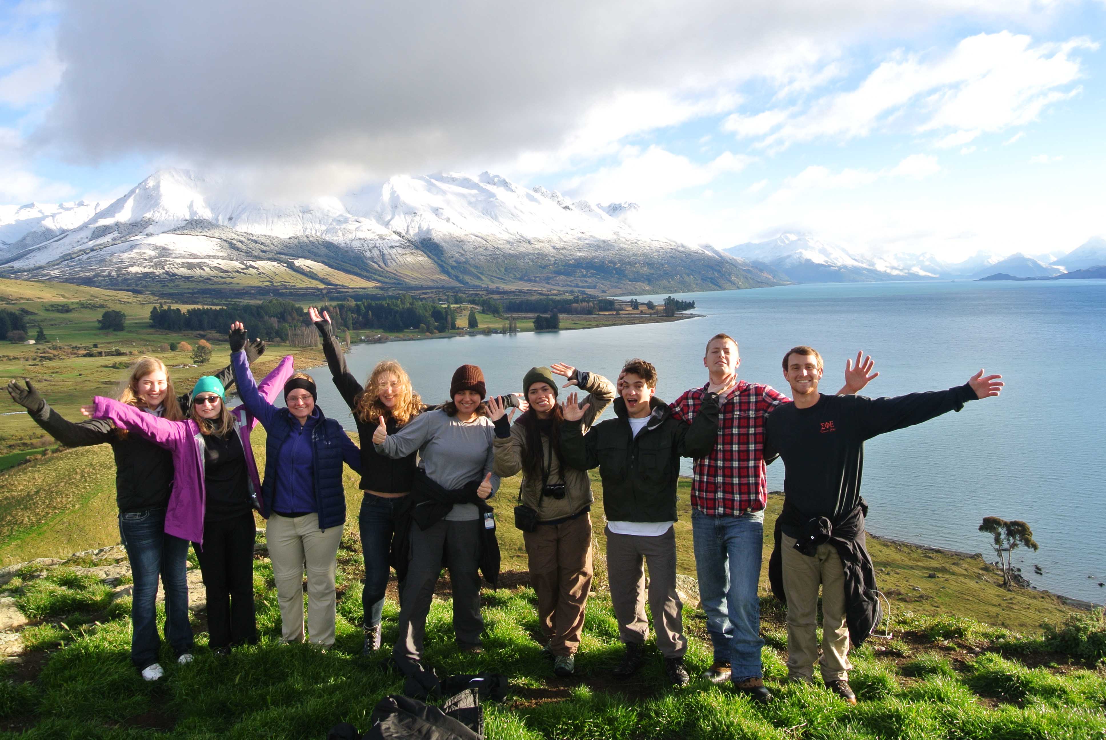 A group of people with their arms spread out enjoying the views in Hawkes Bay, New Zealand.