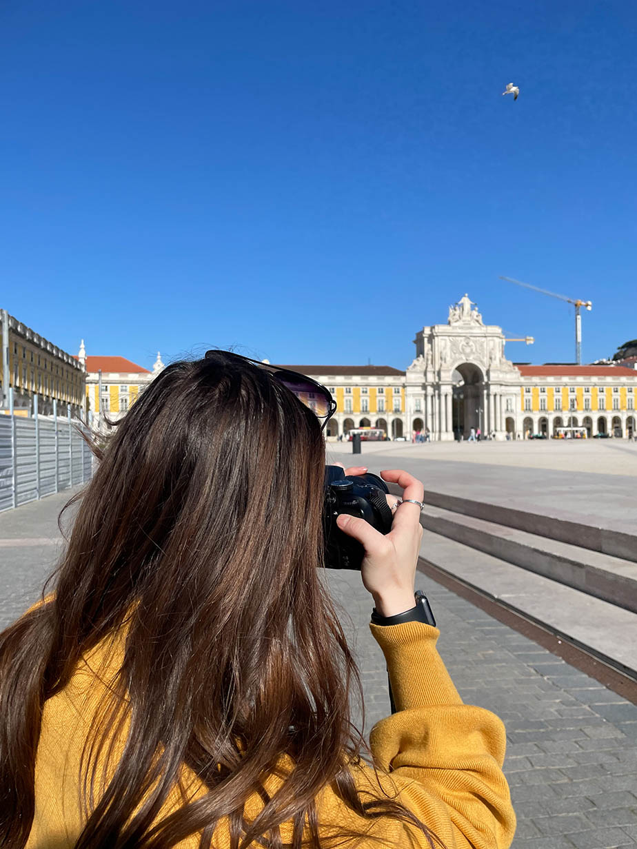 A student taking a photo of historic buildings in Lisbon, Portugal.