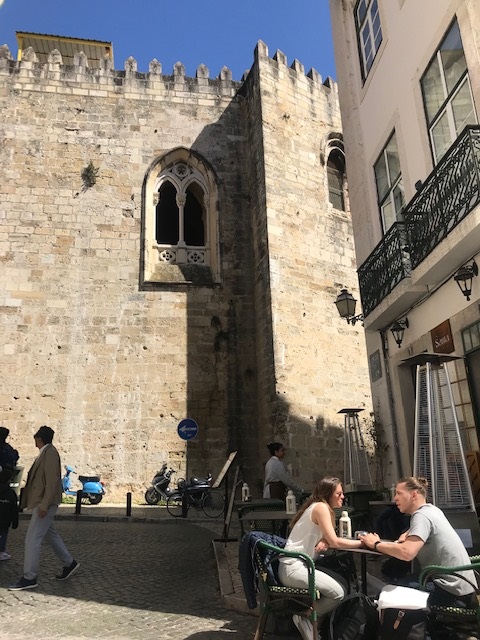 Two people at a table outside a coffee shop in Lisbon, Portugal.