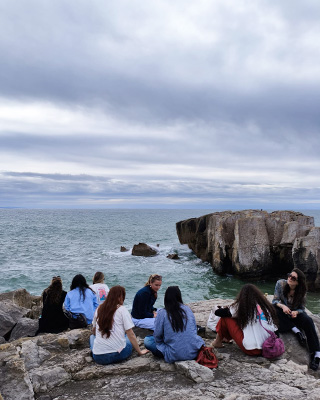 Students sitting on the cliffs overlooking the Peniche coast in Portugal.