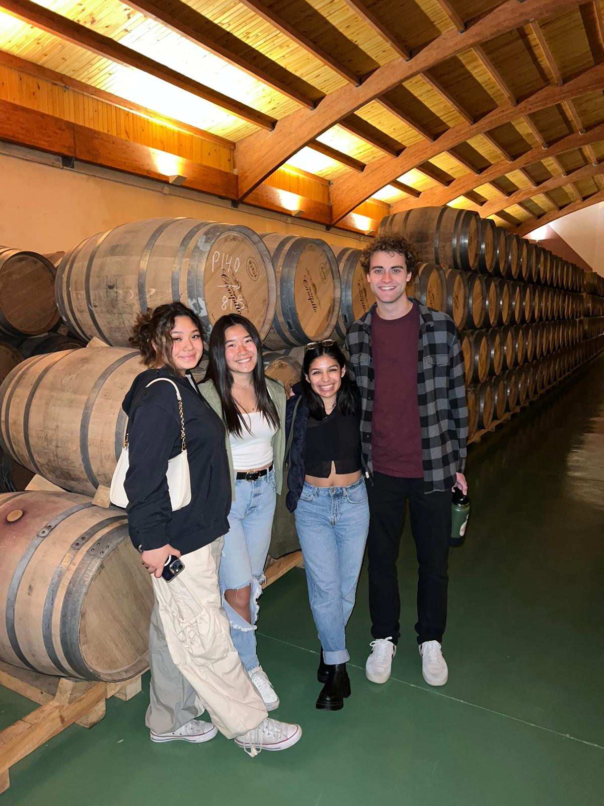 Students standing in front of wine barrels touring one of the many wineries in Laguardia, Spain.