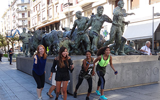 Students mimicking a statue they're standing in front of in Pamplona, Spain.