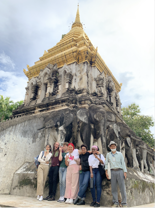 Students and professor posing in front of a traditional Thai Wat in the Old City of Chiang Mai, Thailand.