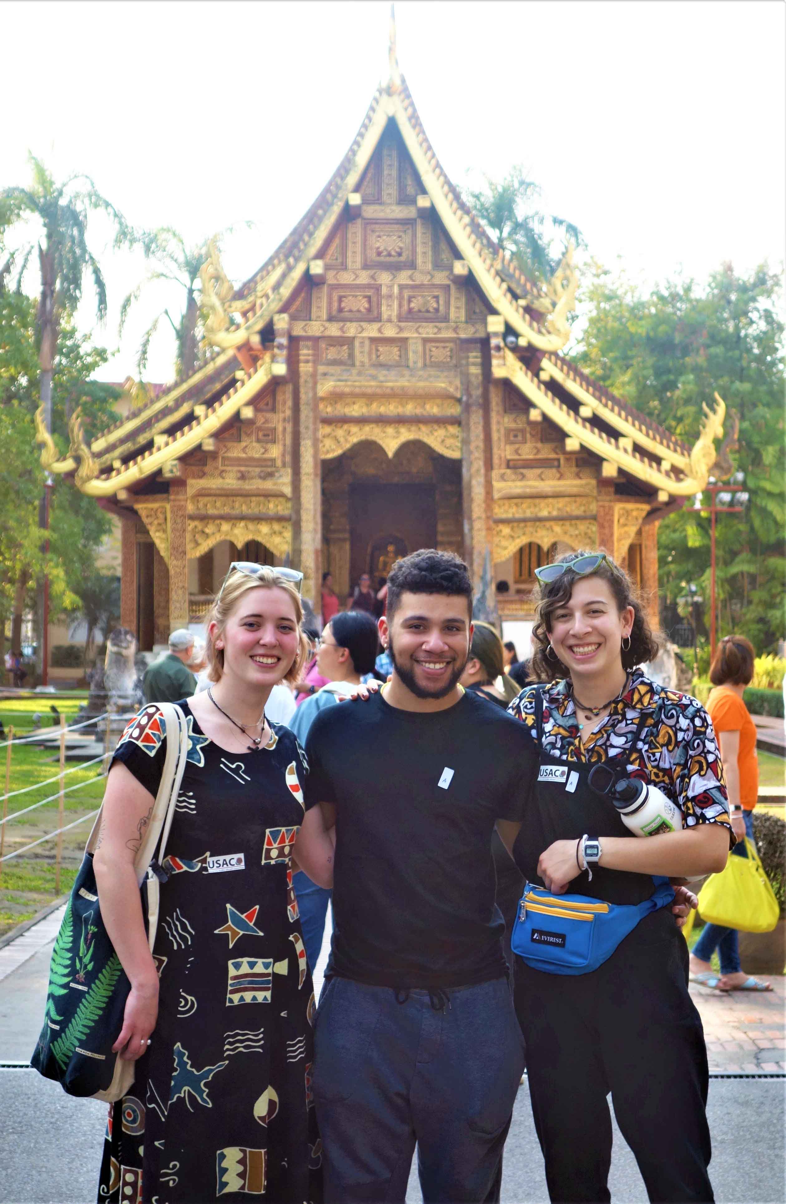 Three students in front of a Thai temple (wat) in Chiang Mai, Thailand.
