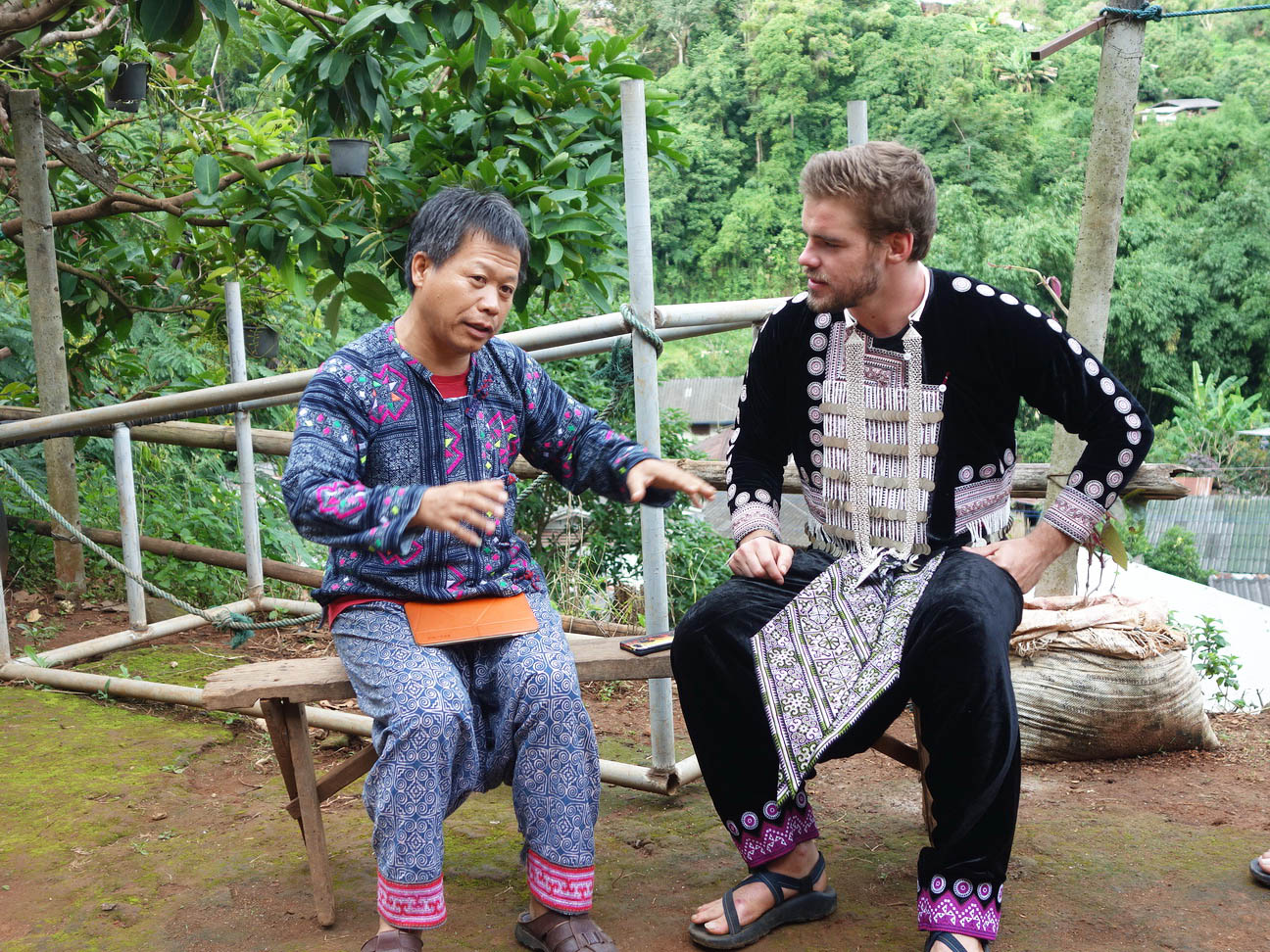 A student chatting with a Hmong man in the Doi Pui Hmong Village in Thailand.