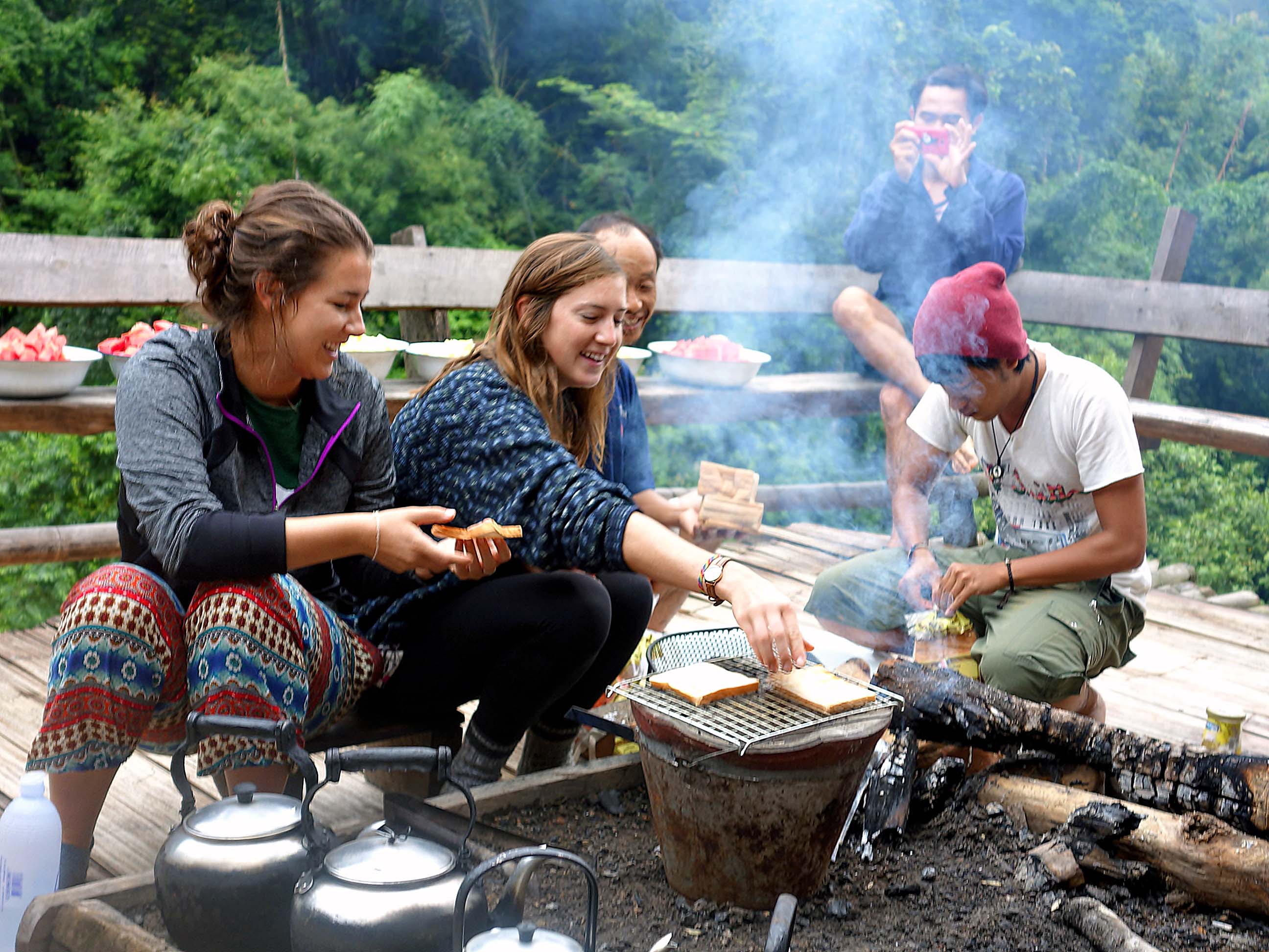 Students cooking a meal over fire while on the trekking tour in the Mae Wang mountains in Thailand.