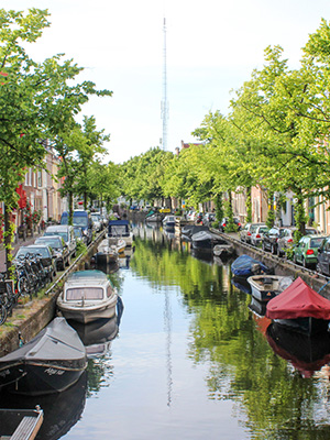 Boats in a canal with historic buildings around it in the Netherlands.